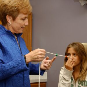 Dr. Hellerstein holding string with beads with patient doing vision therapy