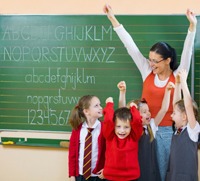 School Kids at Chalkboard with arms raised